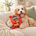 Cockapoo cuddled up with a plush crisps-packet dog toy on a sofa